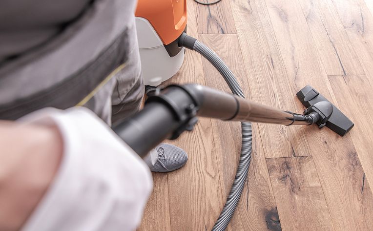 man vacuuming hardwood floor